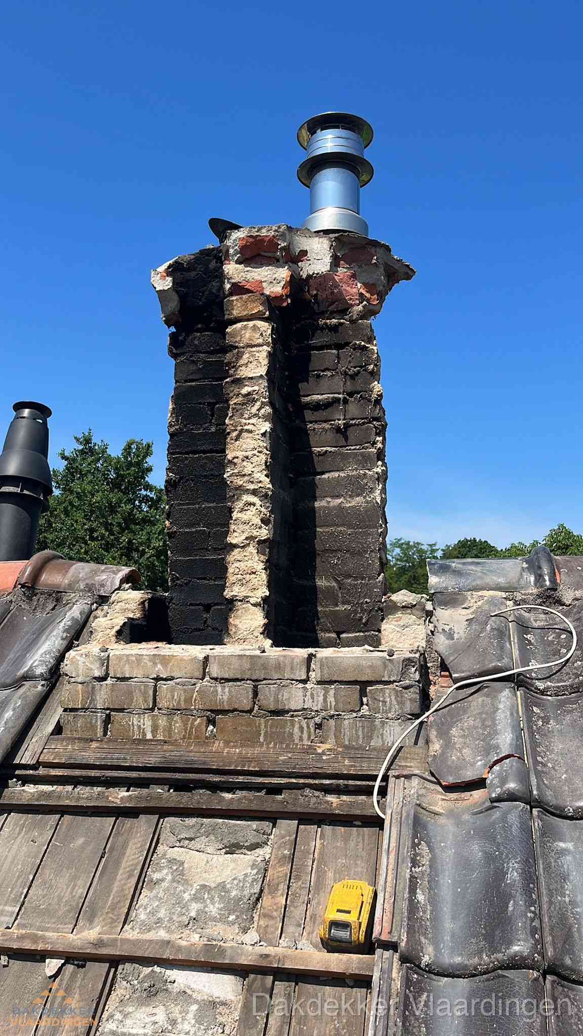 Beschadigde schoorsteen met nieuwe rookgasafvoer op oud dak in Vlaardingen Beschadigde schoorsteen met nieuwe rookgasafvoer op oud dak in Vlaardingen